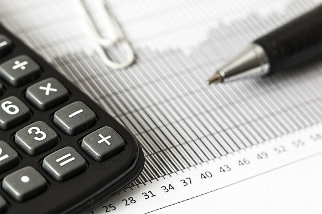 Calculatrice, stylo et graphique financier sur une feuille, représentant des calculs financiers