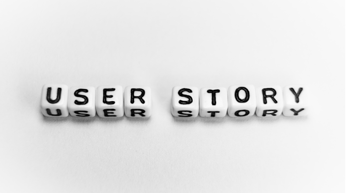 Mot “User Story” écrit avec des cubes blancs à lettres noires sur fond blanc.