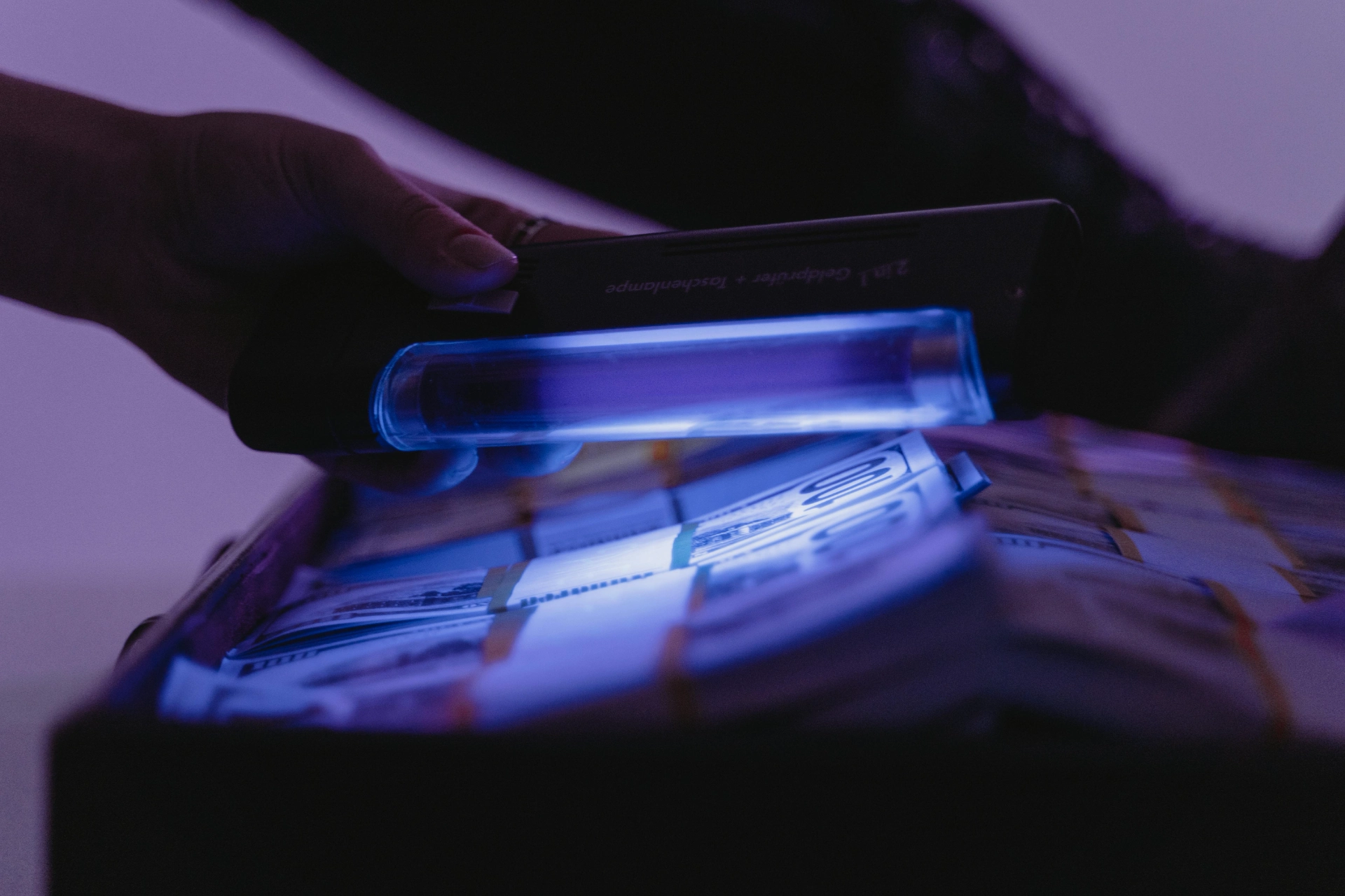 Vérification de billets de banque sous lumière ultraviolette.