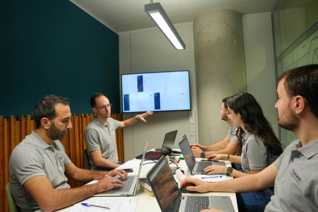 Réunion d’équipe dans une agence web avec présentation de maquettes sur écran.