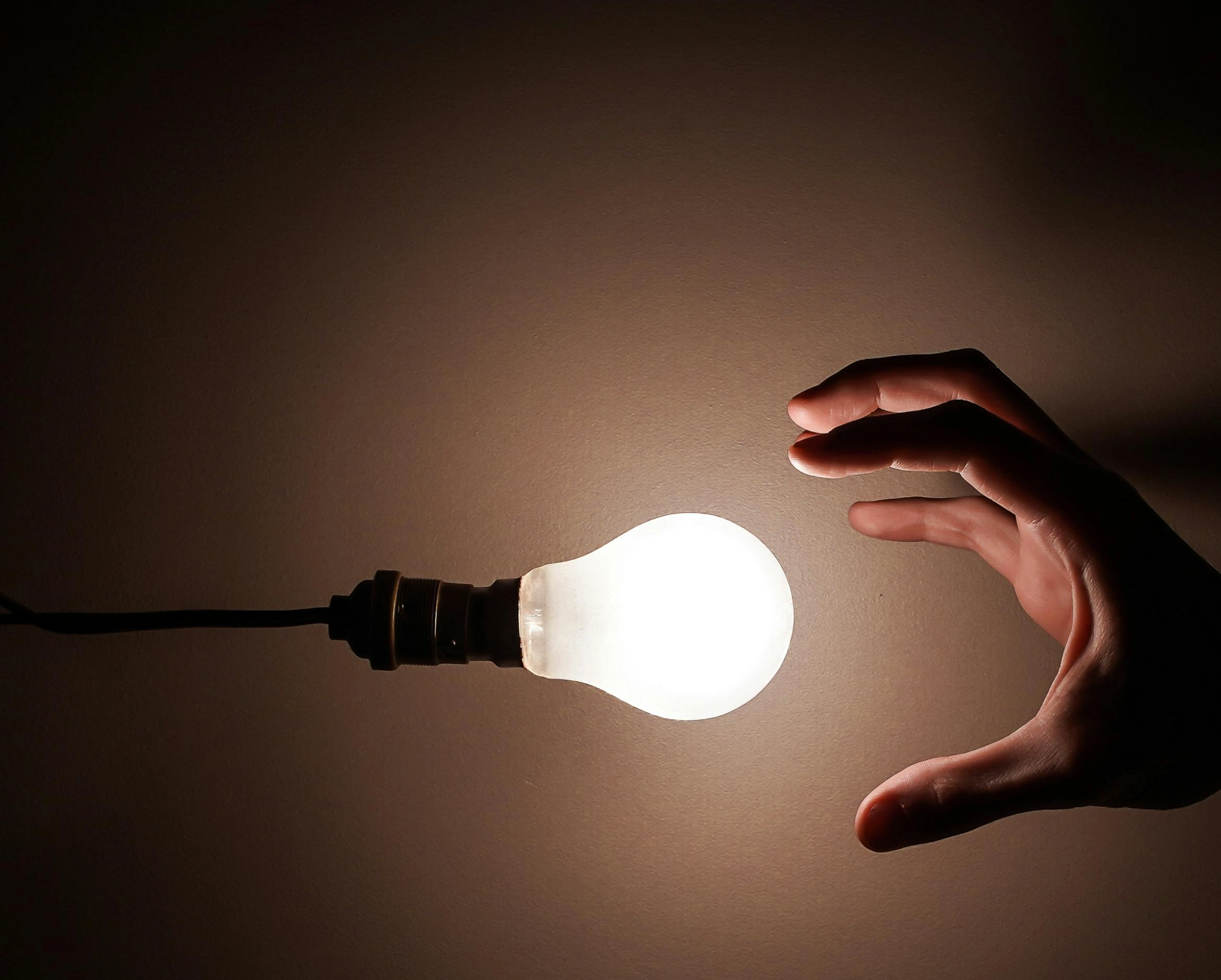 Main tendue vers une ampoule allumée, symbolisant l'idée de création ou d'innovation. Main tendue vers une ampoule allumée, symbolisant l'idée de création ou d'innovation.