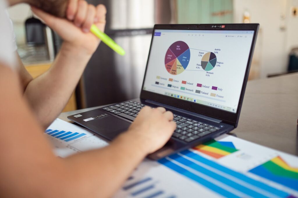 Personne analysant des graphiques circulaires et des courbes de données sur un ordinateur portable.