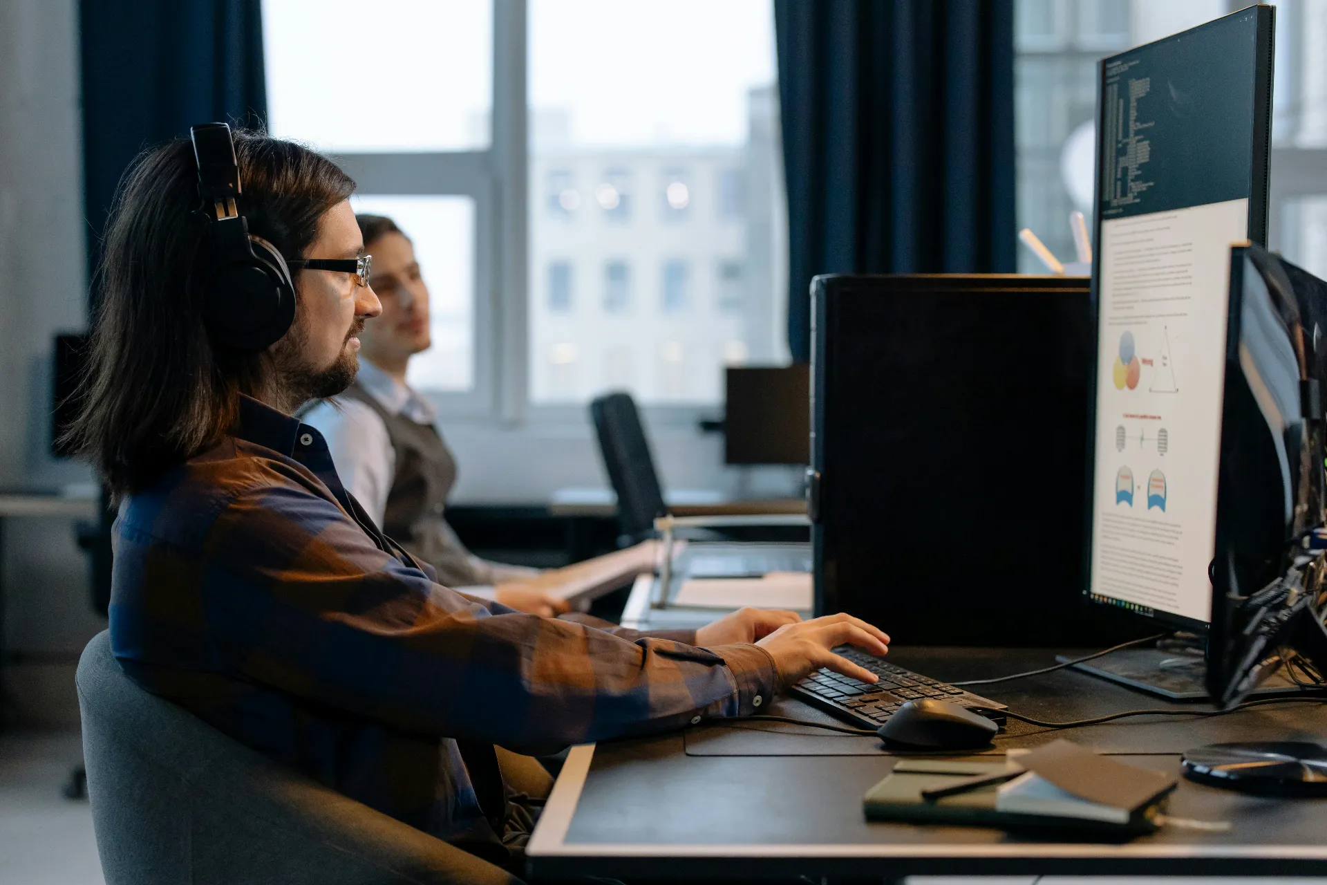 Développeur web travaillant sur ordinateur dans un bureau moderne.