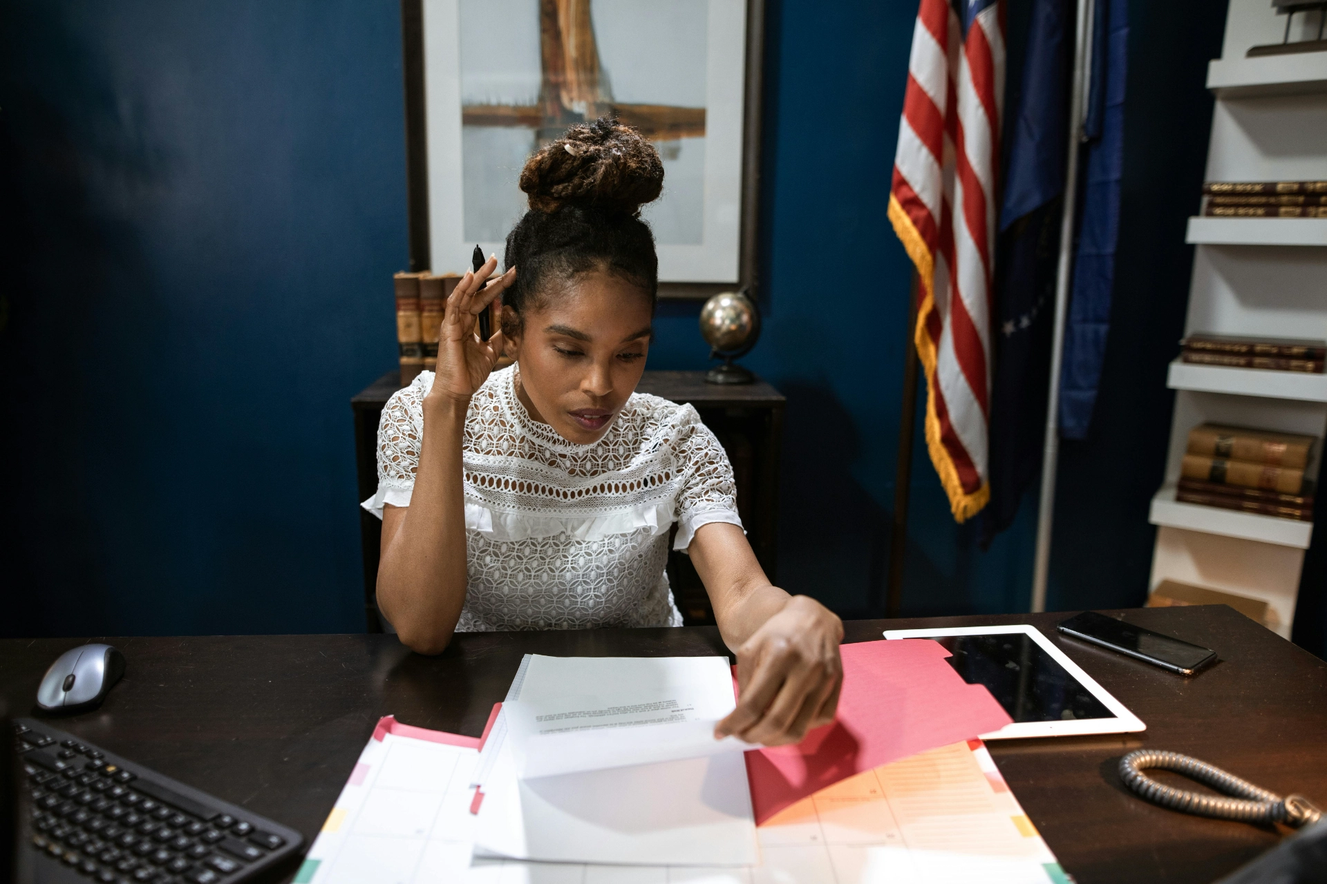 Femme concentrée examinant des documents à son bureau dans un bureau professionnel.