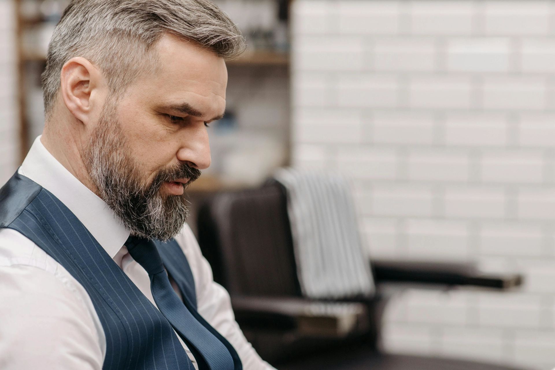 Homme dans un salon de coiffure, concentré sur son apparence.