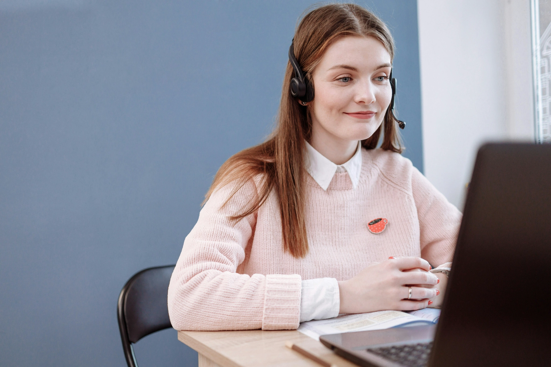 Femme avec un casque micro participant à une visioconférence.